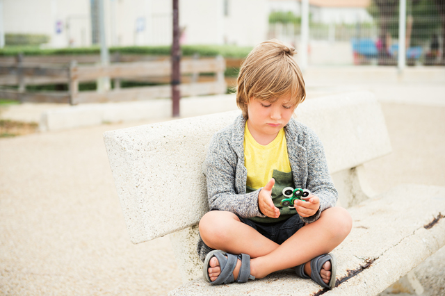 Very-sad-kid-playing-with-fidget-hand-spinners.jpg